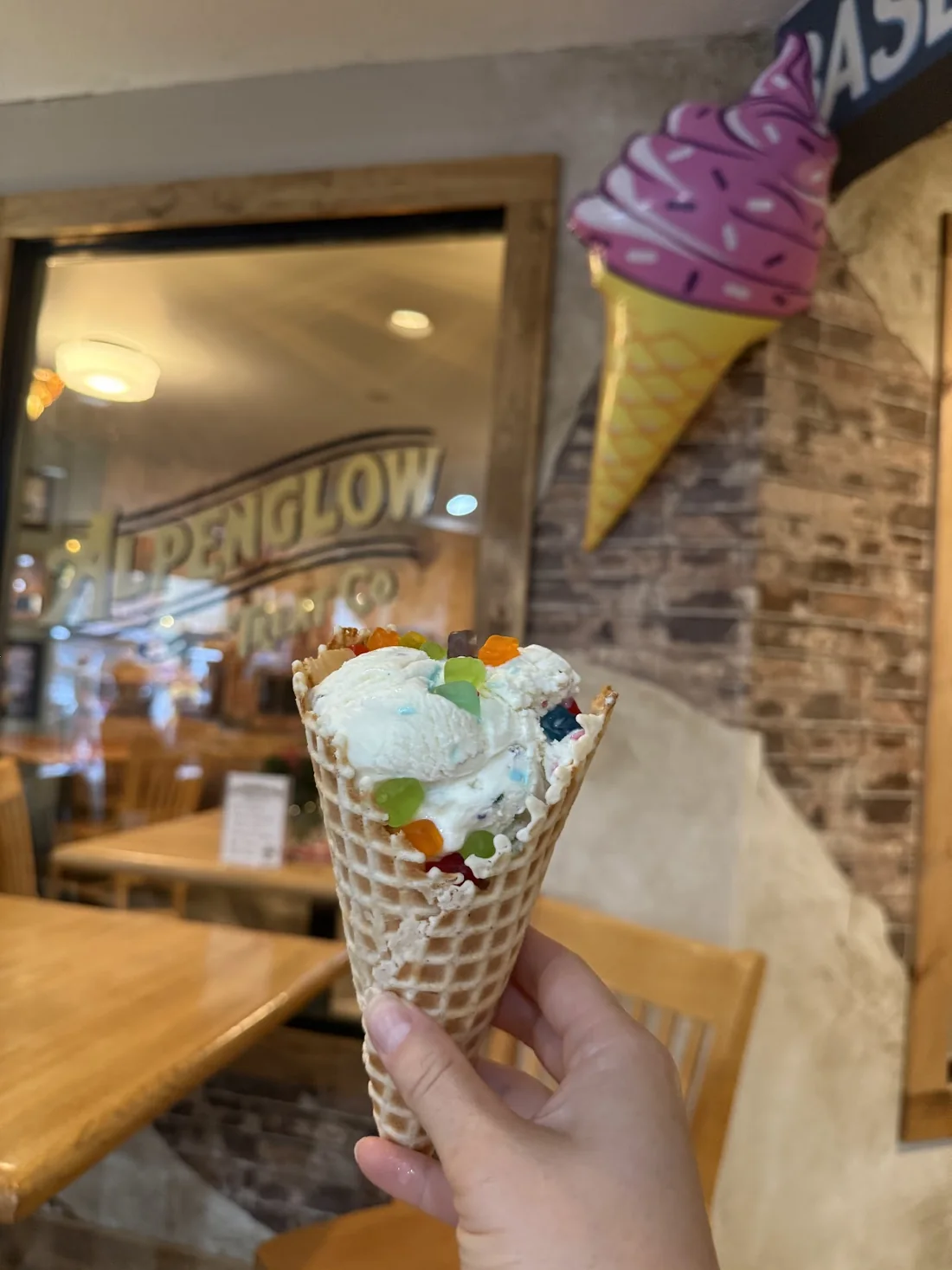 Waffle cone with pale ice cream and colorful gummy candy
